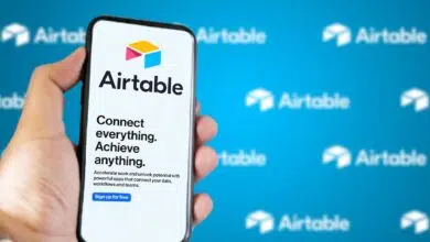 Male hand holding a phone with Airtable company web page on screen