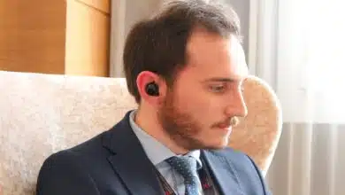 A businessperson wearing the Mymanu CLIK S earbuds