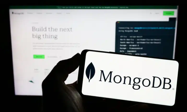 The MongoDB logo on a phone in front of their website.