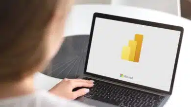 A person loading Microsoft Power BI on a laptop.