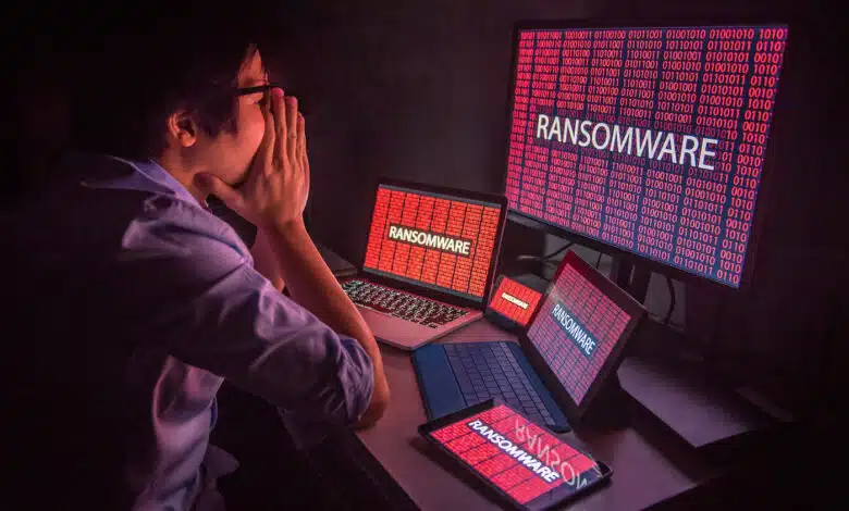 An upset person looking at multiple screens that say ransomware.