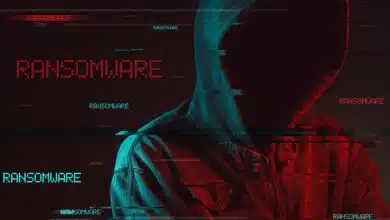 Ransomware concept with faceless hooded male person, low key red and blue lit image and digital glitch effect