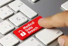 A red Medical Data Breach button on a laptop keyboard.